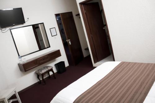 a hotel room with a bed and a mirror at HOTEL ROMO in Ciudad Hidalgo