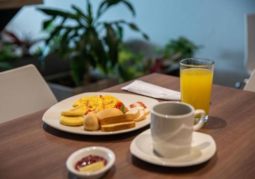 een bord met ontbijtproducten en een kopje jus d'orange bij Hotel Betania in Santa Marta
