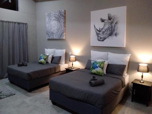 a living room with two beds and a couch at Fijnbosch Game Lodge Jeffreys Bay in Jeffreys Bay