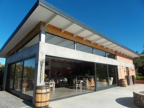 a building with large glass windows and a patio at Fijnbosch Game Lodge Jeffreys Bay in Jeffreys Bay