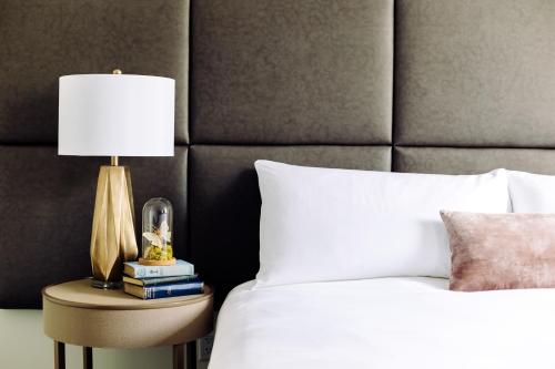 a bed with a lamp on a night stand next to a bed at Hotel Deco in Omaha