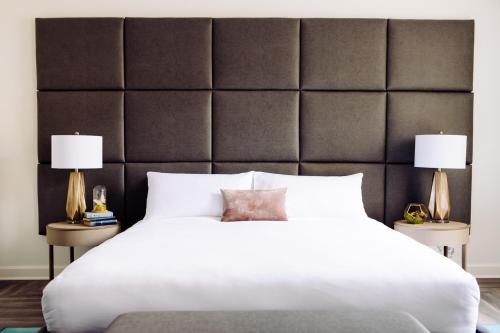a bedroom with a large white bed with two lamps at Hotel Deco in Omaha
