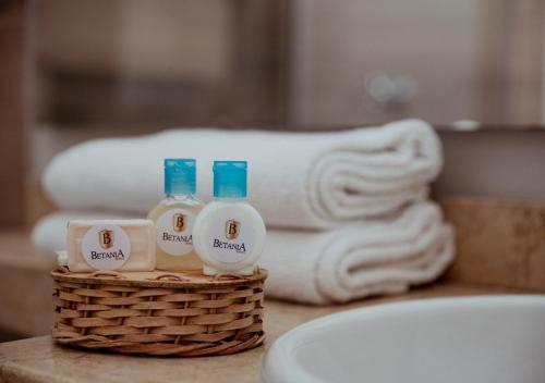 - Cesta de artículos de aseo en la barra del baño con toallas en Hotel Betania, en Santa Marta