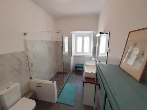 une salle de bain avec un lavabo, des toilettes et un miroir dans l'établissement Do Campo à Praça, à Golegã