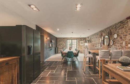 a kitchen and dining room with a table and chairs at Domaine Sur Les Sarts in Ohey