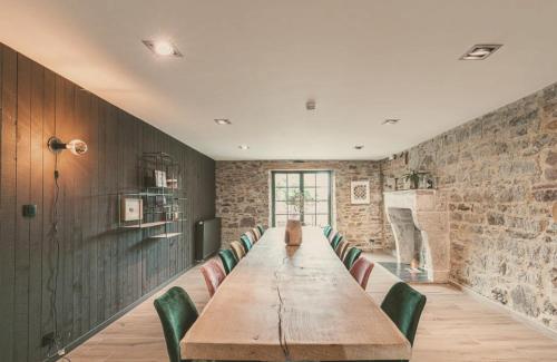 a conference room with a long table and green chairs at Domaine Sur Les Sarts in Ohey