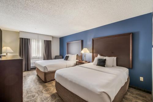 two beds in a hotel room with blue walls at Red Lion Inn & Suites Sequim at Olympic National Park in Sequim