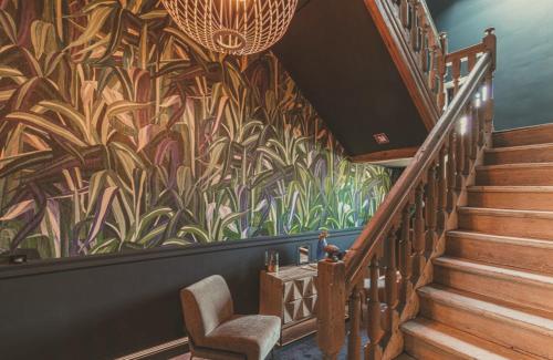 a staircase with a mural of plants on the wall at Domaine Sur Les Sarts in Ohey