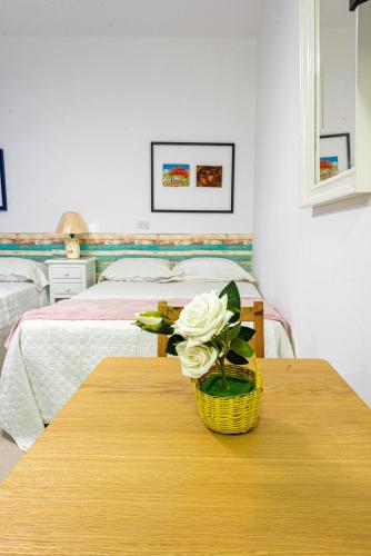 a bedroom with a table with a basket of flowers on it at Bamboo Hoouse in Santo Domingo