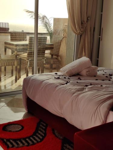 a person laying on a bed in a room with a balcony at House Viola in Imsouane