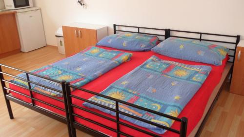 a bedroom with a bed and two pillows at Apartman Vilo in Veľký Meder