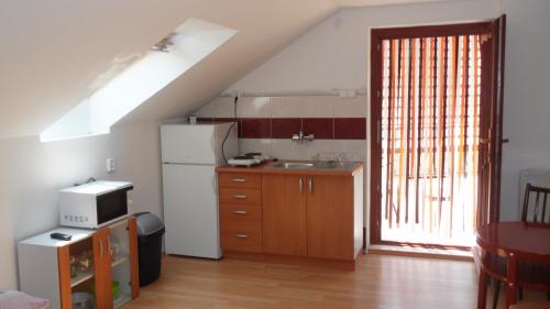 a kitchen with a white refrigerator and a sink at Apartman Vilo in Veľký Meder