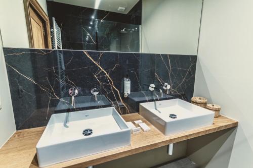 a bathroom with two sinks and a mirror at Domaine Sur Les Sarts in Ohey