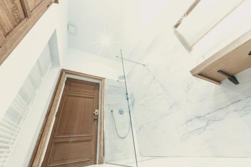 a bathroom with a shower and a wooden door at Domaine Sur Les Sarts in Ohey