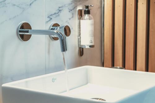 a bathroom sink with water running from a faucet at Domaine Sur Les Sarts in Ohey
