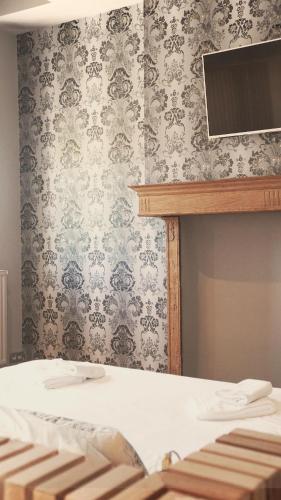 a bedroom with a bed and a wall with wallpaper at Domaine Sur Les Sarts in Ohey