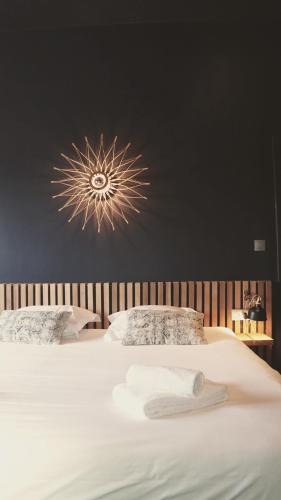 a bedroom with a bed with a chandelier on the wall at Domaine Sur Les Sarts in Ohey