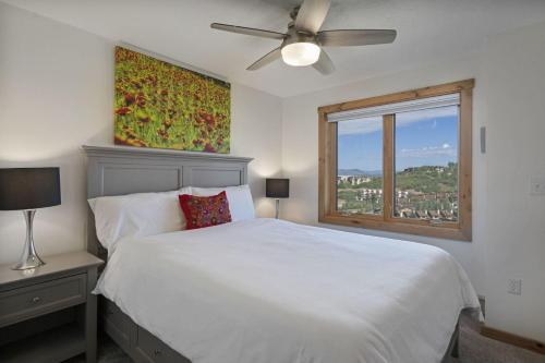 a bedroom with a white bed and a window at Bear Claw 514 - Bear Claw II Building in Steamboat Springs