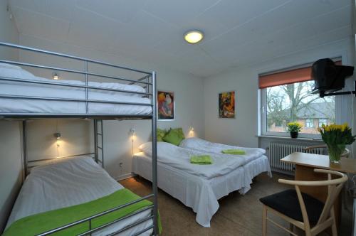 a bedroom with two bunk beds and a desk at Thyregod Kursuscenter in Thyregod