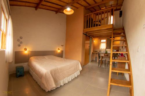 een slaapkamer met een bed en een ladder in een kamer bij Vila do Lago in São Bento do Sapucaí