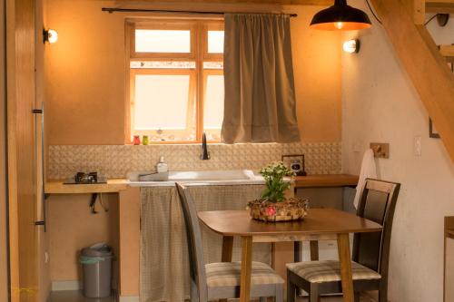 a small kitchen with a table and a sink at Vila do Lago in São Bento do Sapucaí