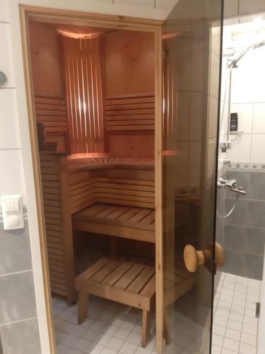 a shower stall with wooden shelves in a bathroom at Sun in Närpiö
