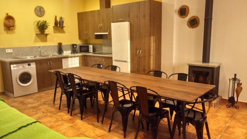 una cocina con una gran mesa de madera y sillas en Casa Rural Sierra de las Nieves, en Yunquera