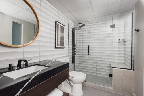 a bathroom with a sink and a toilet and a mirror at Hotel Deco in Omaha