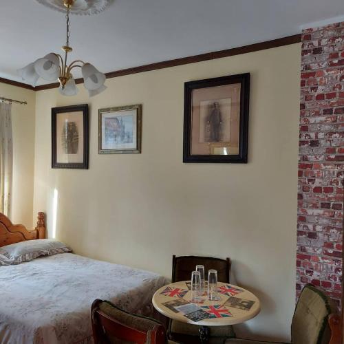 a bedroom with a bed and a table with chairs at Willa Zamkowisko in Gołubie