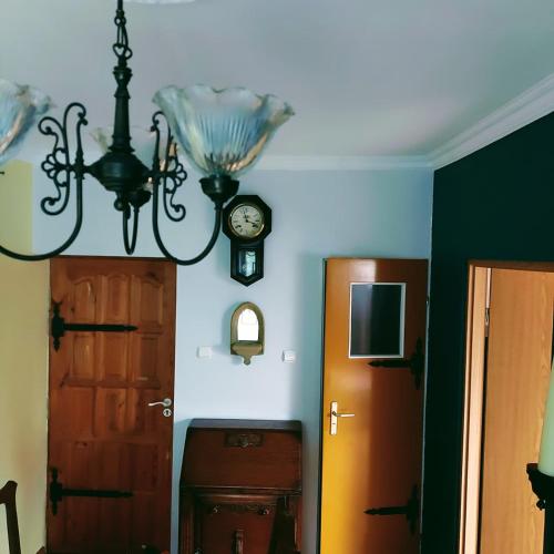 a room with a chandelier and a door and a clock at Willa Zamkowisko in Gołubie