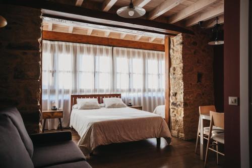a bedroom with a bed and a large window at Casa Rosales ( Posada Rural) in Cardes