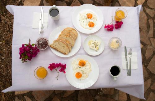 a table with plates of eggs and bread on it at Filoxenia - The Place of Experience in Himare