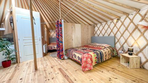 a room with two beds in a yurt at Au bois de Mars in Les Martys