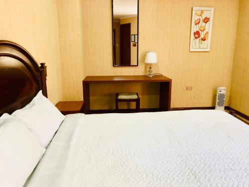 a bedroom with a bed and a desk with a mirror at Quito Terrace in Quito