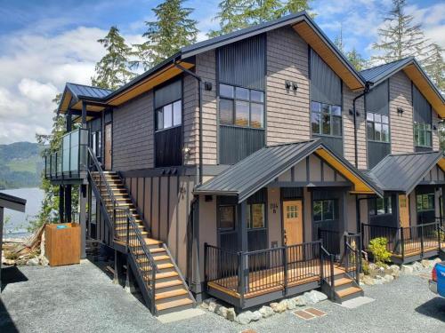 a house with a staircase leading up to it at Port Renfrew Oceanfront Retreat in Port Renfrew