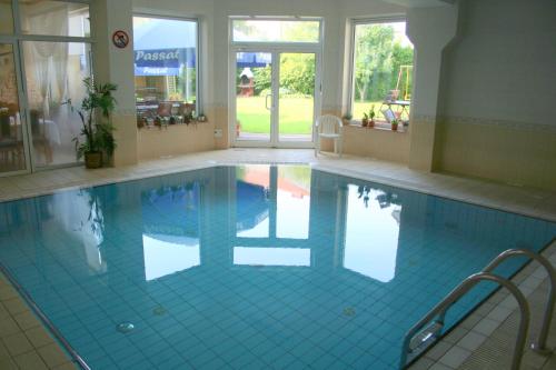 a swimming pool with blue tiles in a building at Dom Wypoczynkowy Passat in Niechorze