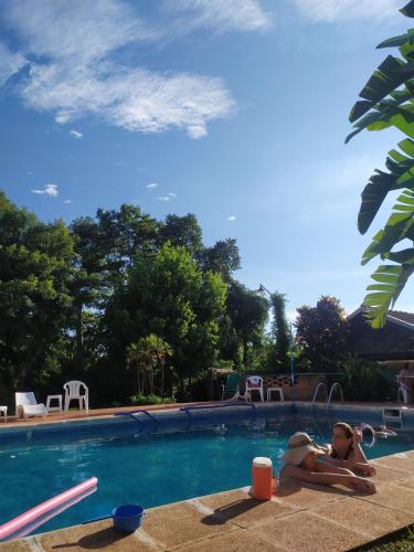 two people sitting in a swimming pool at Hosteria Helvecia in Montecarlo