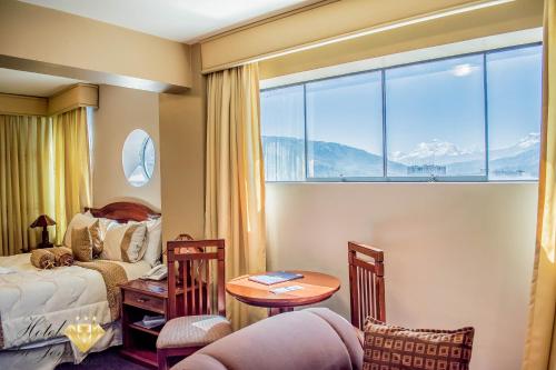 1 dormitorio con cama, mesa y ventana en Hotel La Joya, en Huaraz