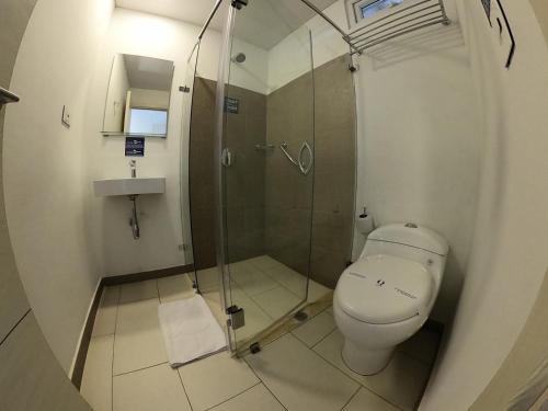 a bathroom with a toilet and a glass shower at Hotel Quinto Nivel in San José del Guaviare