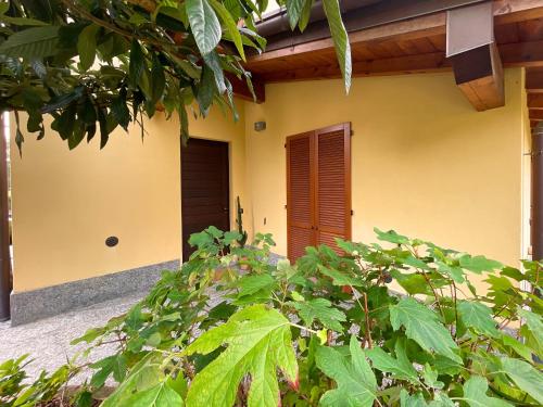 a yellow house with a door and some plants at Entire accommodation with private garden near Milan and Lake Como - Free parking - Family friendly in Seregno