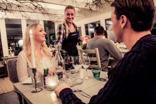 a group of people sitting at a table with wine glasses at Hotell Mossbylund in Abbekås