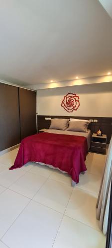 a bedroom with a large bed with a red headboard at Flat Tabatinga Nord, vista para o mar in Conde