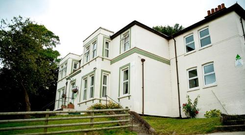 a white house with a fence in front of it at YHA Streatley on Thames in Streatley