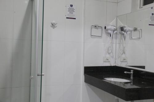 a bathroom with a sink and a shower at Hotel Brasilia Curitiba in Curitiba