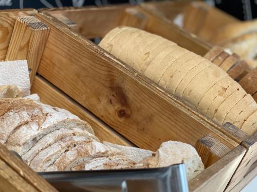 uma bandeja de madeira cheia de diferentes tipos de pão em Hotel Kapital em Maputo