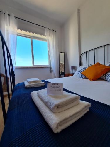 a bedroom with a bed with towels on it at City Centre Apartment Setubal in Setúbal