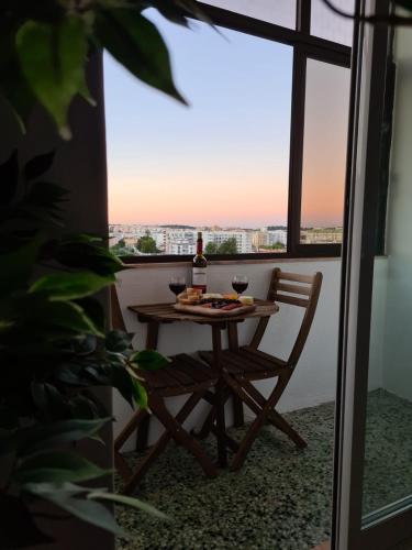 a table and a chair on a balcony with a view at City Centre Apartment Setubal in Setúbal