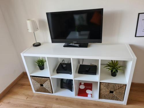 a white entertainment center with a tv on top at City Centre Apartment Setubal in Setúbal