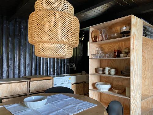 una cucina con tavolo e lampadario pendente di Ca Pedrot Do-Minus Mountain Cottage & mini spa a Monte Carasso