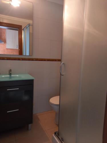een badkamer met een toilet, een wastafel en een spiegel bij Ca Isaak in Denia